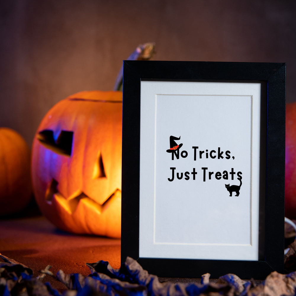 No trick just treats printable wall art  in a black frame with a Halloween decorations