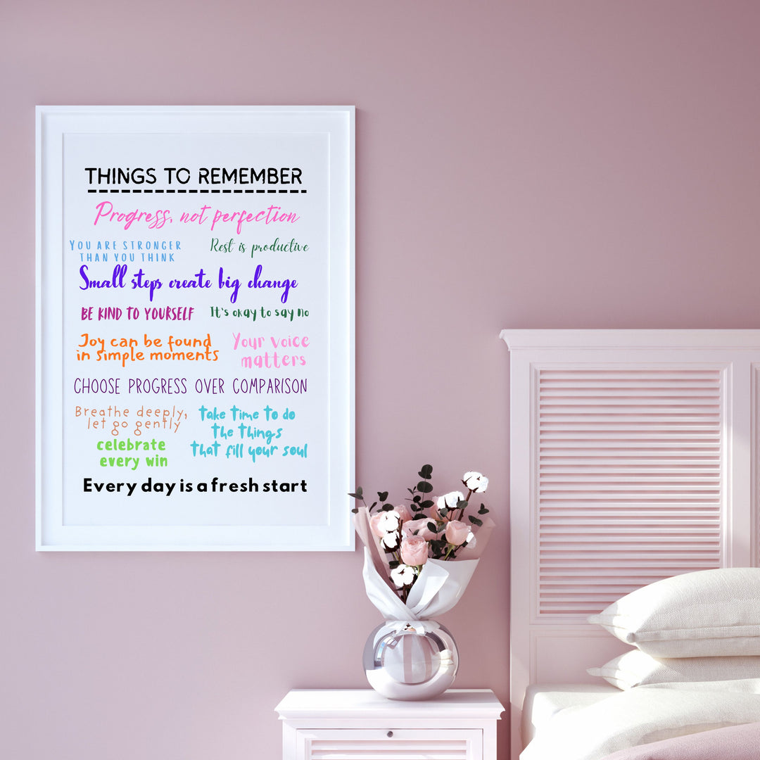 Motivational poster on a pink wall with a vase of flowers and white bedding.