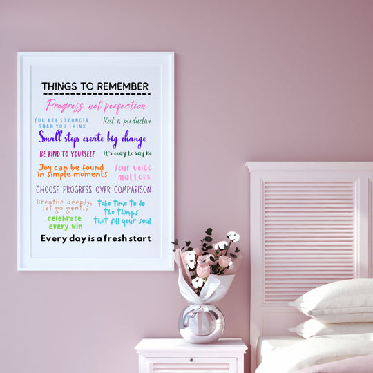 Motivational poster on a pink wall with a vase of flowers and white bedding.