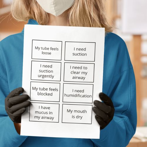 Person wearing a face mask and gloves holding a sheet of paper with medical symptoms.