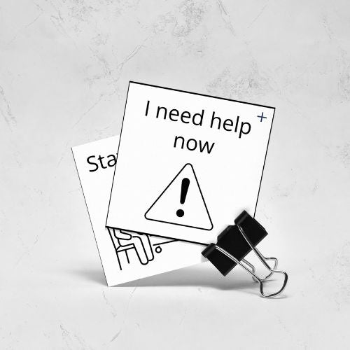 Two black and white signs with text and a warning symbol on a light gray background.
