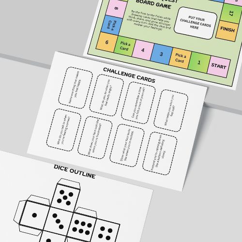 Educational materials including a board game template, challenge cards, and a dice outline on a gray surface.