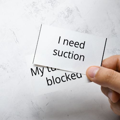 Hand holding a piece of paper with text on a light gray background