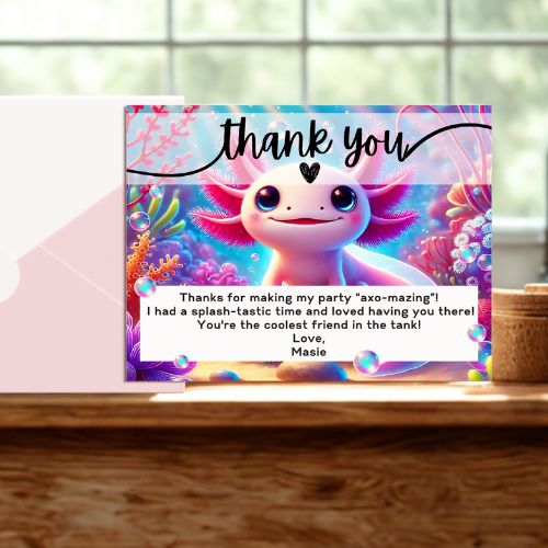Colorful card with axolotl character and 'thank you' message on a wooden surface.