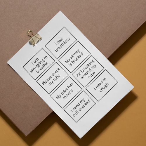 Sheet of paper with medical communication phrases on a brown background