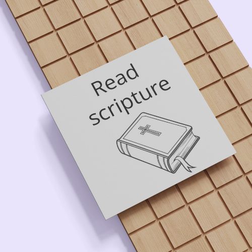 Note with 'Read scripture' text and a Bible illustration on a wooden surface